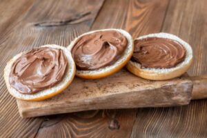 crema spalmabile su tre fette di pane sopra ad un tagliere