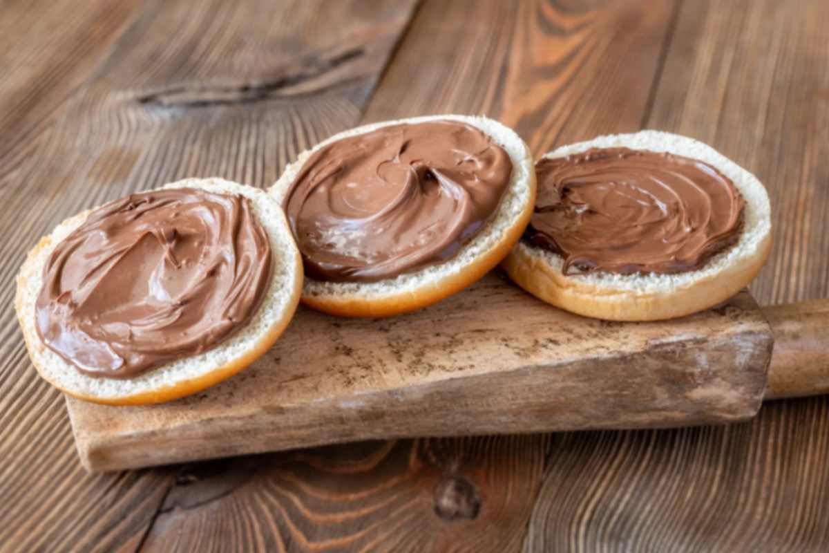 jene-stephaniuk-lkmGeyLItrw-unsplash-ls crema spalmabile su tre fette di pane sopra ad un tagliere