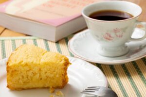fetta di torta su un piattino e dietro una tazza di tè